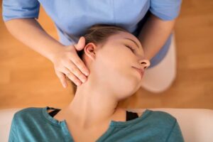 A person relaxing with improved posture after a spinal adjustment in a calm, bright clinic room.